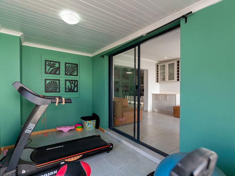 A covered patio area featuring tiled flooring and sliding glass doors that open into the main living space.