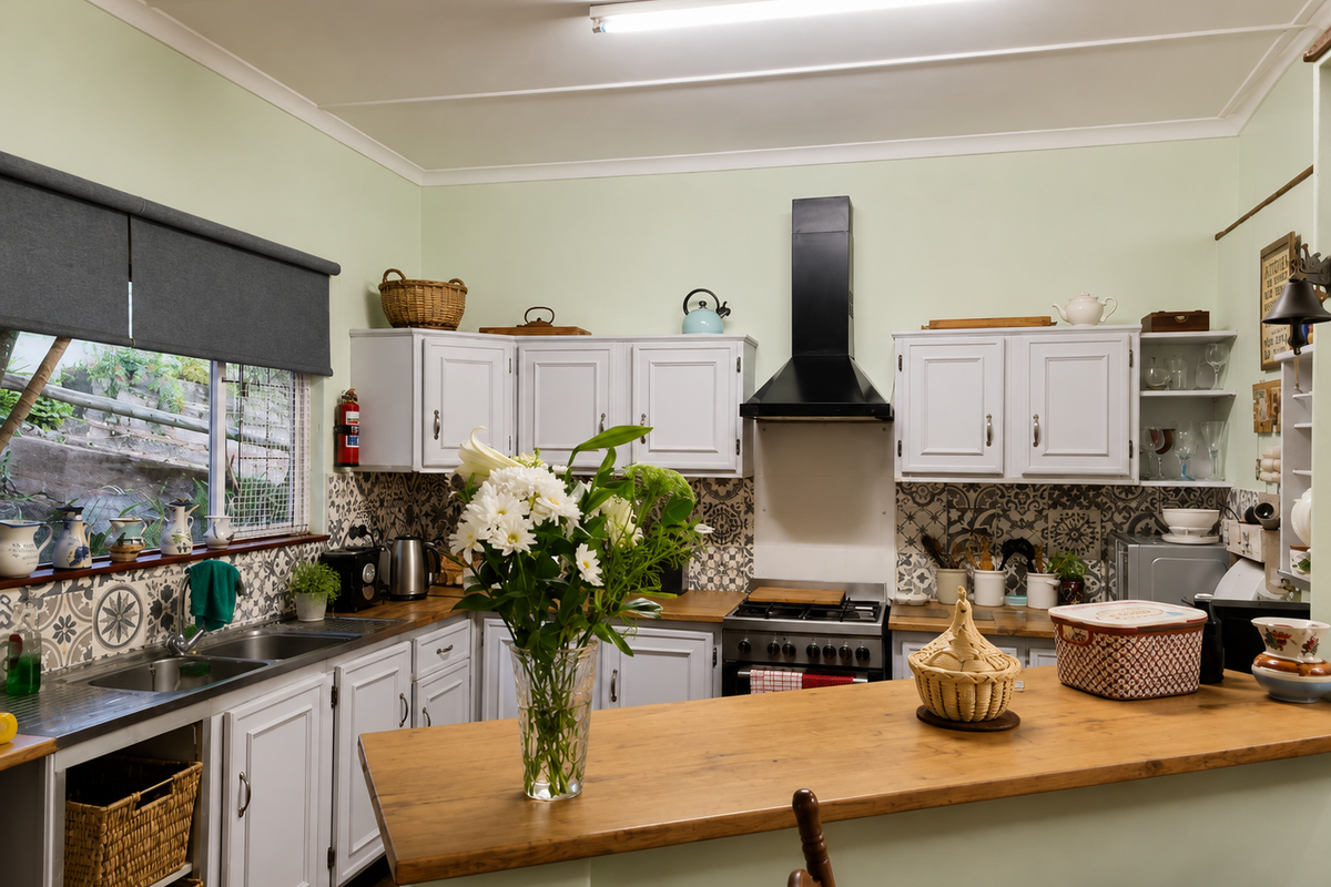A functional kitchen featuring white cabinetry, wooden countertops, a patterned tile backsplash, and a built-in gas stove with an extractor fan.