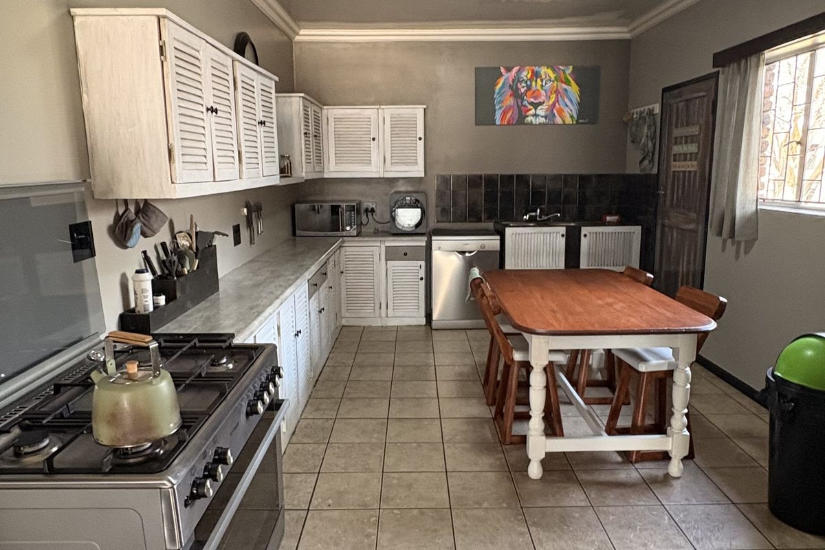 A functional kitchen featuring tiled flooring, built-in cabinetry, a gas stove with oven, and a tiled backsplash, offering a practical layout for daily use.