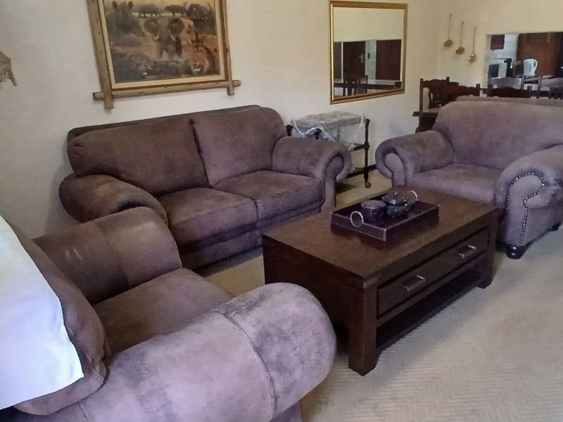 A comfortable living room area featuring carpeted flooring and a convenient pass-through window connecting to the adjacent kitchen space.