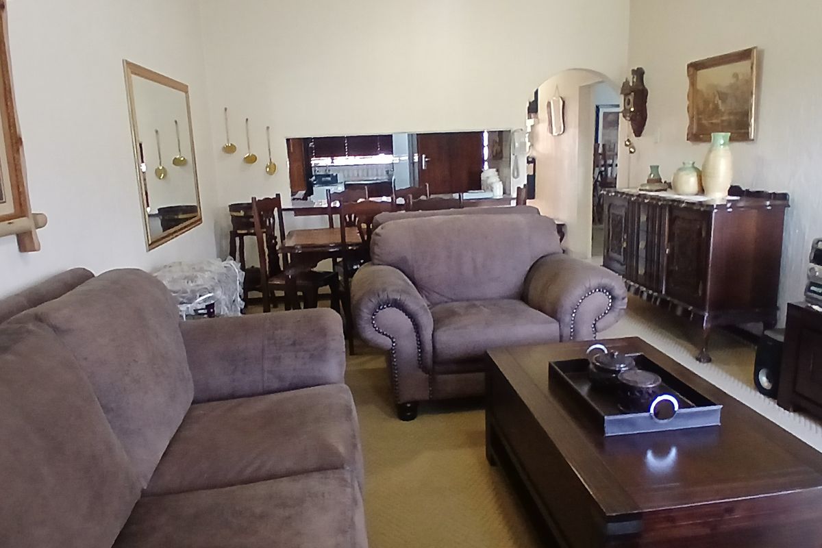 A living room featuring an arched entryway and a serving hatch connecting to the adjacent dining area.