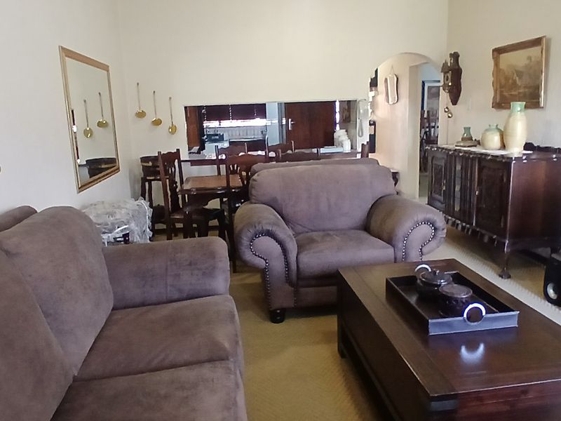 A living room featuring an arched entryway and a serving hatch connecting to the adjacent dining area.
