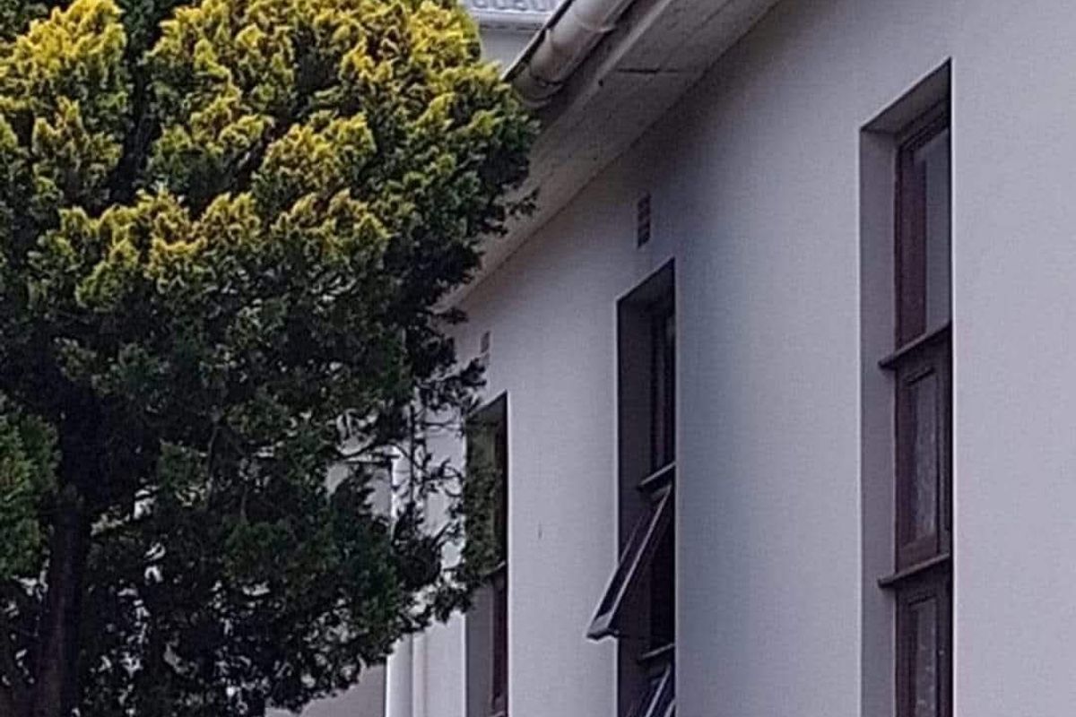 Side profile of the property showing exterior wall, metal roofing, and window fixtures.