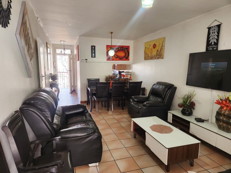 Open plan living and dining area featuring tiled flooring and direct access to an outdoor balcony space.