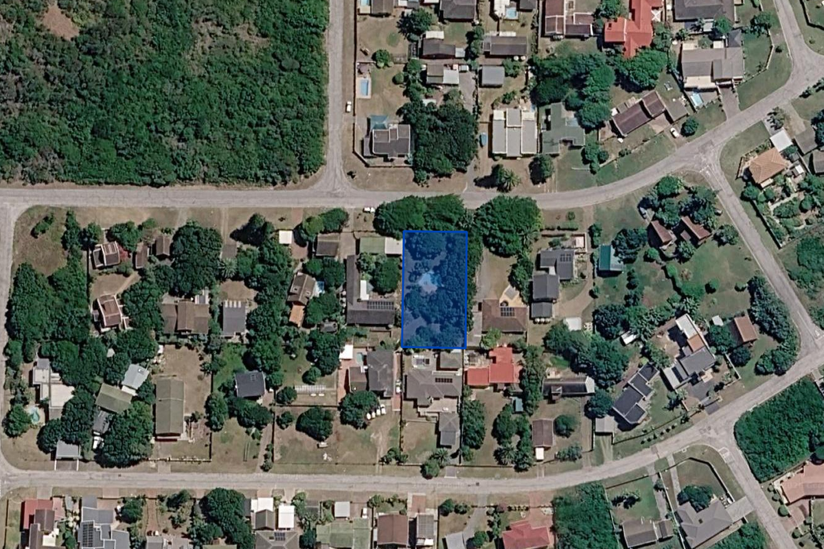 An aerial view of a vacant residential plot situated within an established suburban neighborhood, highlighting the property boundaries and surrounding residential context.