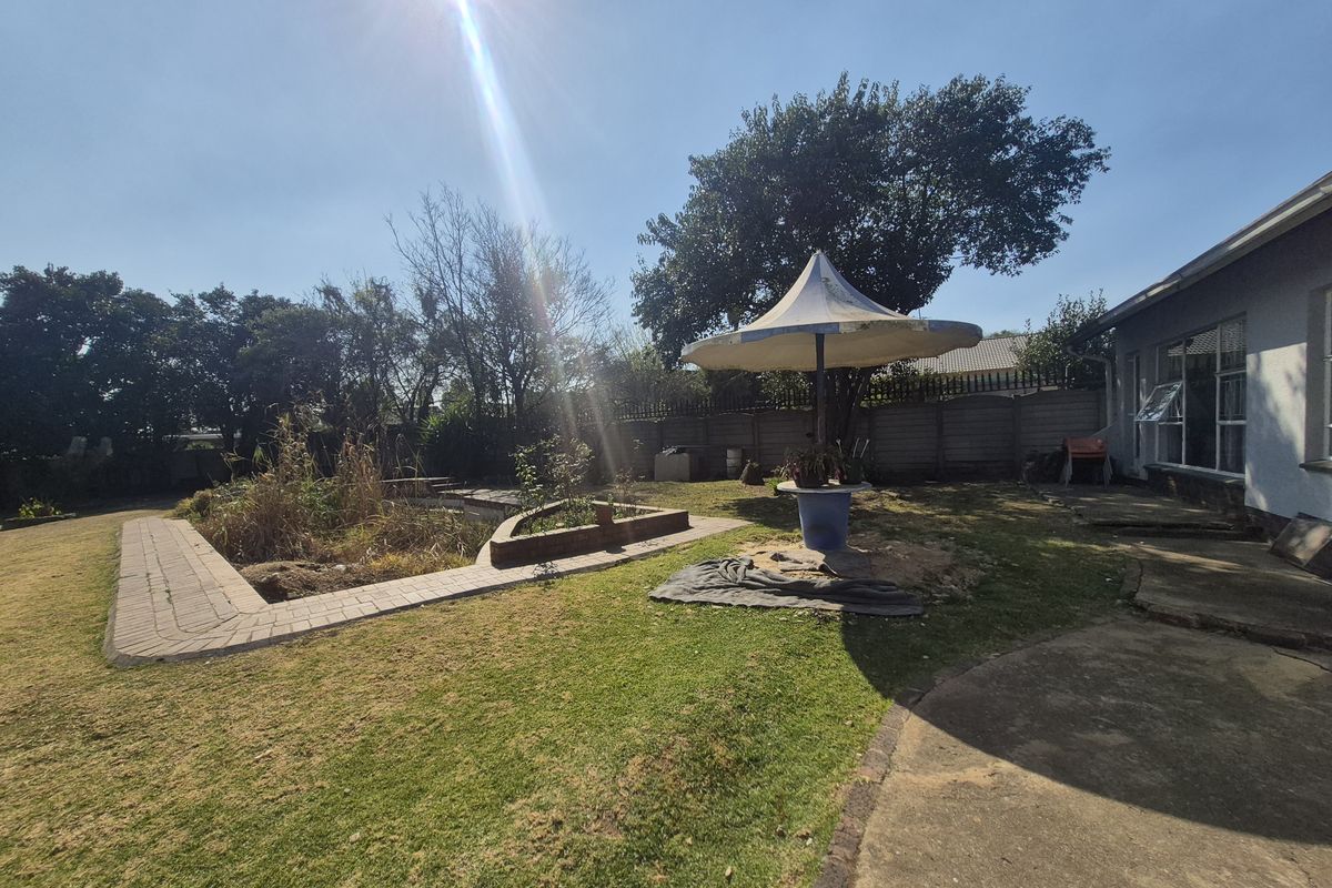 Rear garden featuring a swimming pool, paved walkways, and a concrete patio area, requiring significant landscaping and maintenance to restore its appeal.