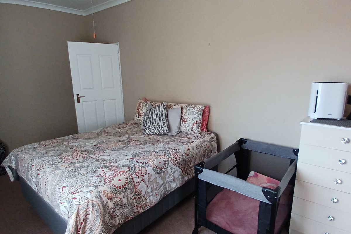 A standard bedroom featuring neutral wall tones, cove cornicing, and a classic panel door, providing a functional and comfortable living space.