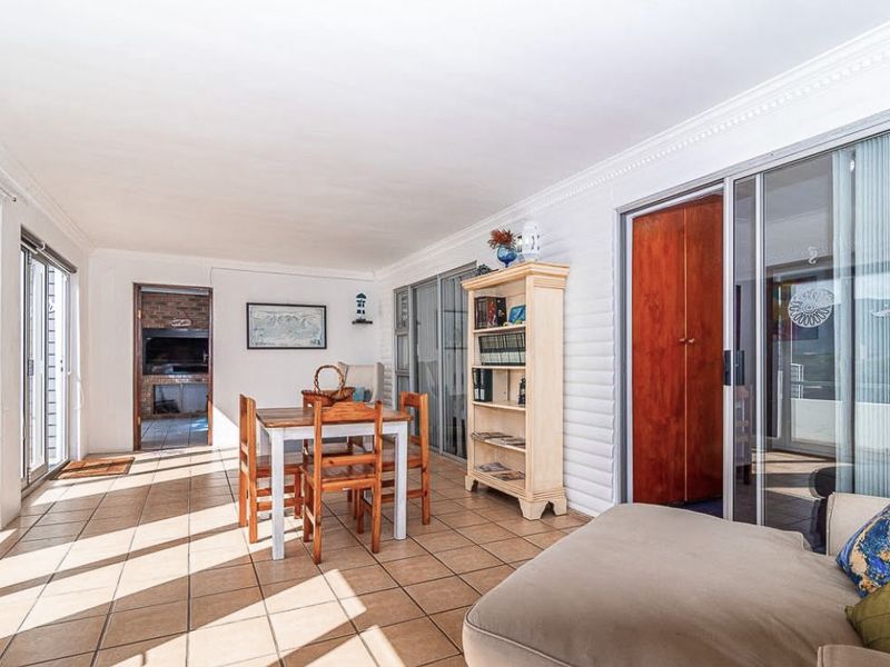 Spacious enclosed patio featuring tiled flooring, sliding glass doors providing natural light, and access to an internal brick fireplace area.