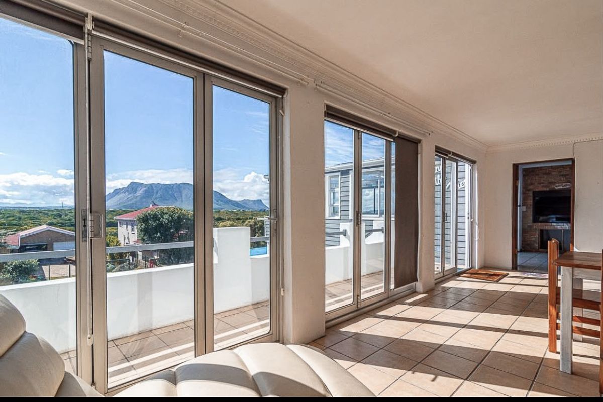 Bright living area featuring large sliding glass doors that open onto a balcony, offering scenic mountain views and abundant natural light.