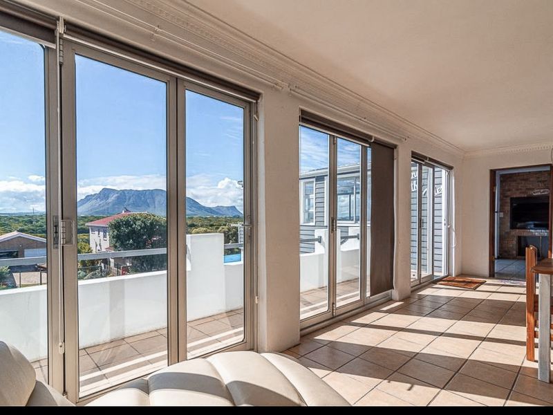 Bright living area featuring large sliding glass doors that open onto a balcony, offering scenic mountain views and abundant natural light.