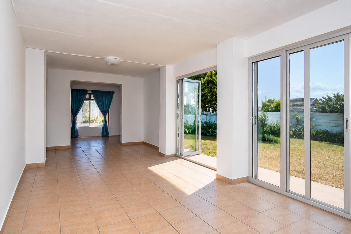 Spacious, light-filled living area featuring neutral tiled flooring and large aluminium sliding and folding doors providing seamless access to the rear garden.