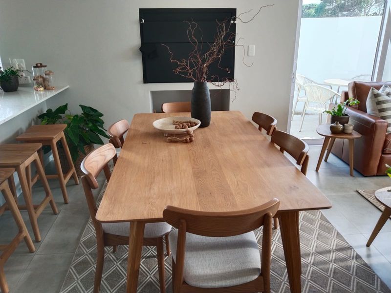 Open plan dining area featuring tiled flooring, a built-in fireplace, and seamless access to an outdoor patio through sliding glass doors.