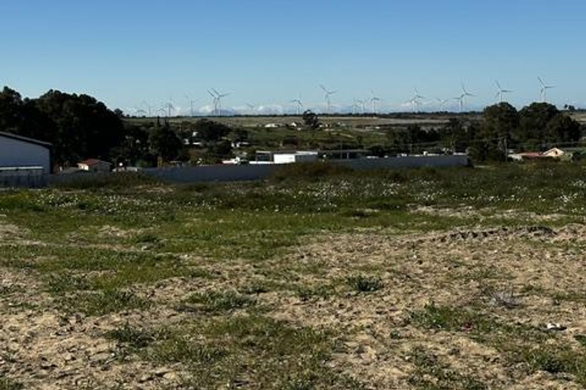 A view across the vacant residential land towards the surrounding landscape and distant wind turbines.