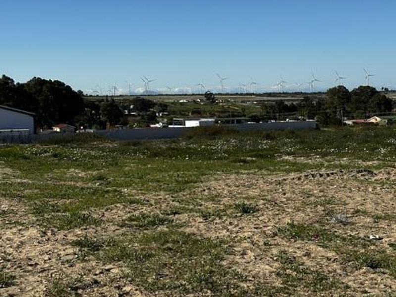 A view across the vacant residential land towards the surrounding landscape and distant wind turbines.