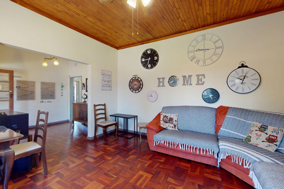 A living room featuring warm parquet flooring and a classic wooden ceiling, creating a cozy and traditional atmosphere.