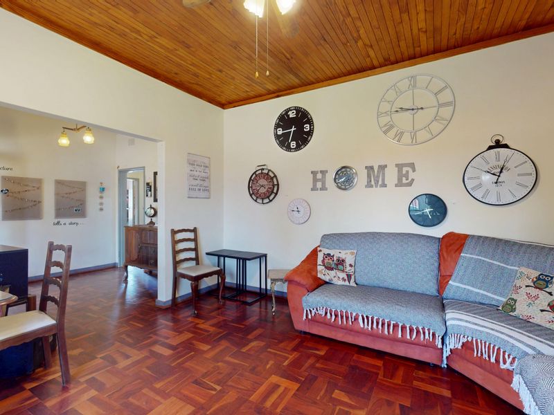 A living room featuring warm parquet flooring and a classic wooden ceiling, creating a cozy and traditional atmosphere.