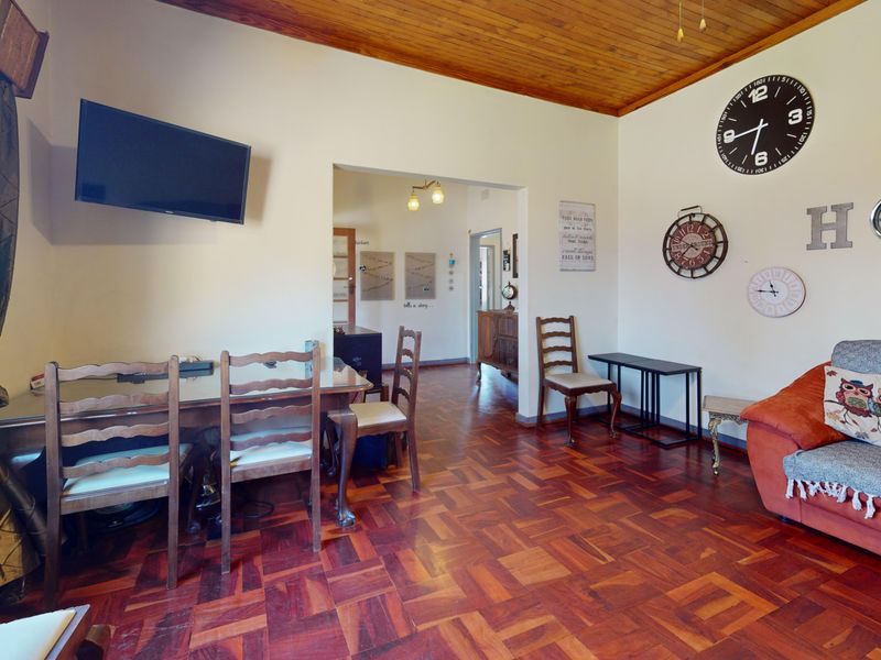 A living area featuring warm parquet flooring and a classic timber-paneled ceiling, offering a traditional aesthetic with potential for modern updates.