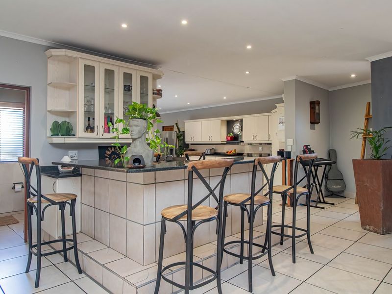 Open-plan living area featuring a tiled kitchen island with granite countertops and ample built-in cabinetry, seamlessly connecting to the surrounding living space.