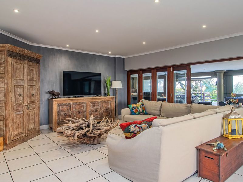 Spacious living room featuring tiled flooring, recessed downlights, and large sliding glass doors that open onto an adjoining patio area.