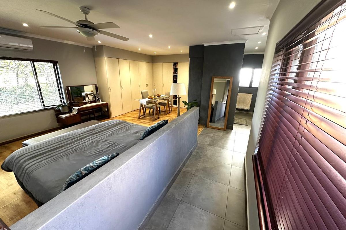 Spacious bedroom featuring built-in cupboards, tiled flooring, recessed lighting, a ceiling fan, and an integrated air conditioning unit.
