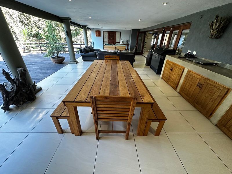 Spacious covered patio featuring tiled flooring, built-in cabinetry with a concrete countertop, and recessed lighting, ideal for outdoor entertaining.