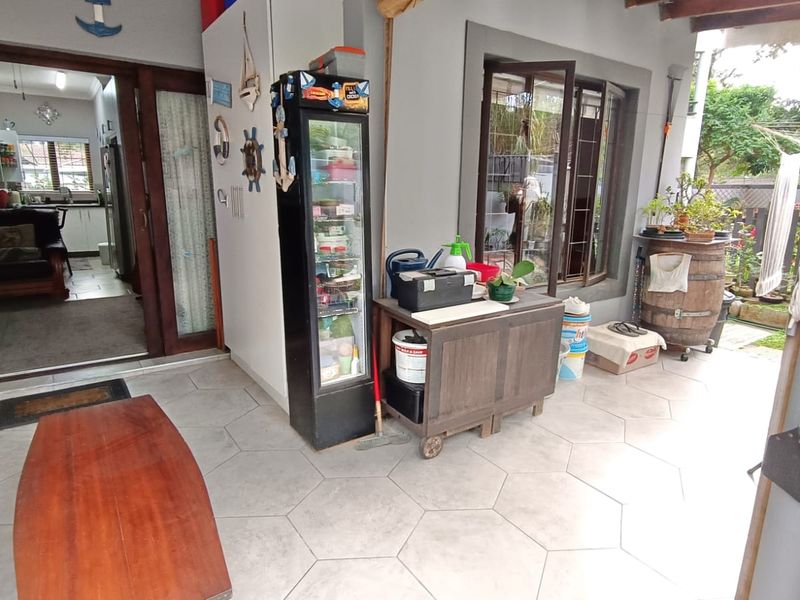 A covered patio area featuring tiled flooring and access to the interior living space through large sliding glass doors.