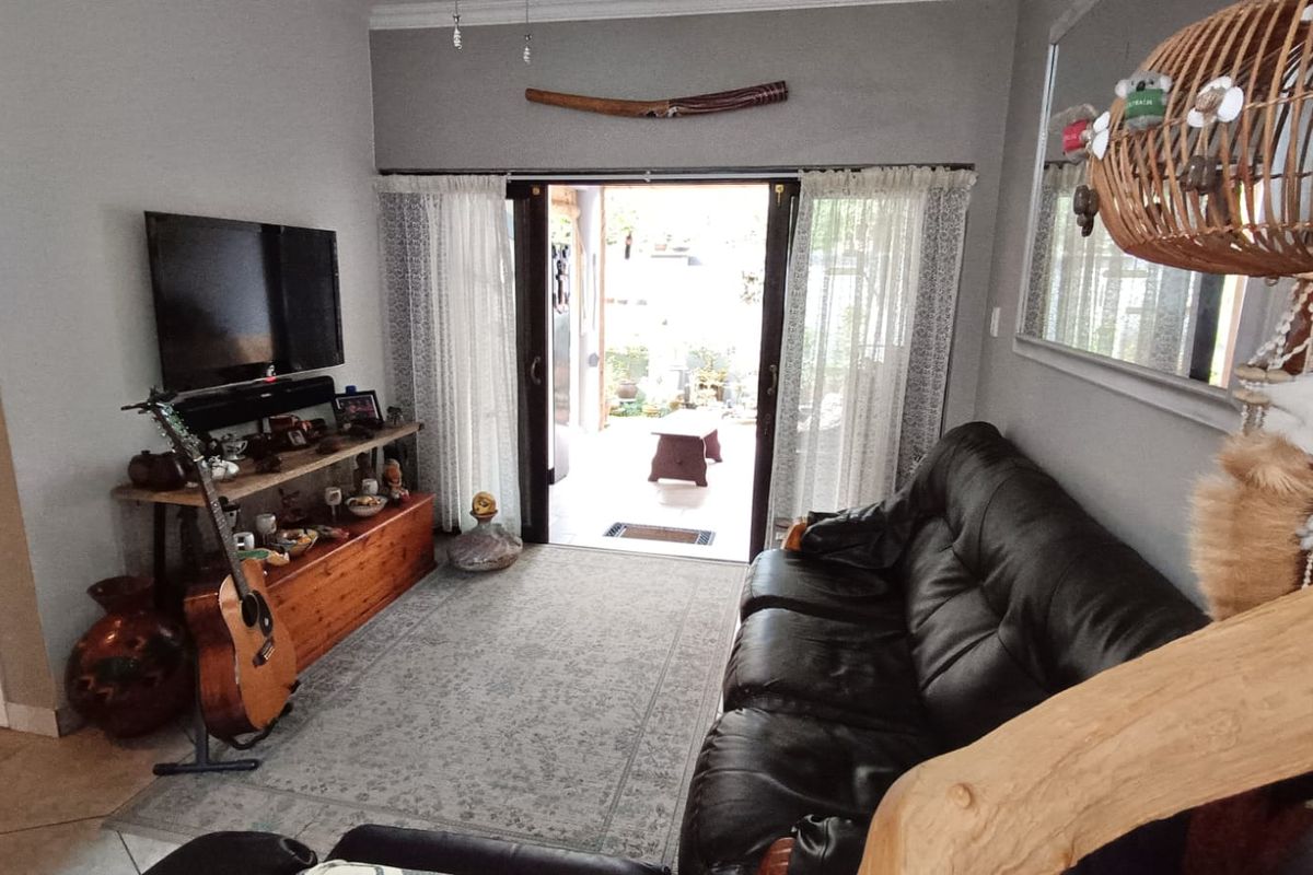 A living room featuring tiled flooring and a sliding glass door providing direct access to an outdoor patio area.