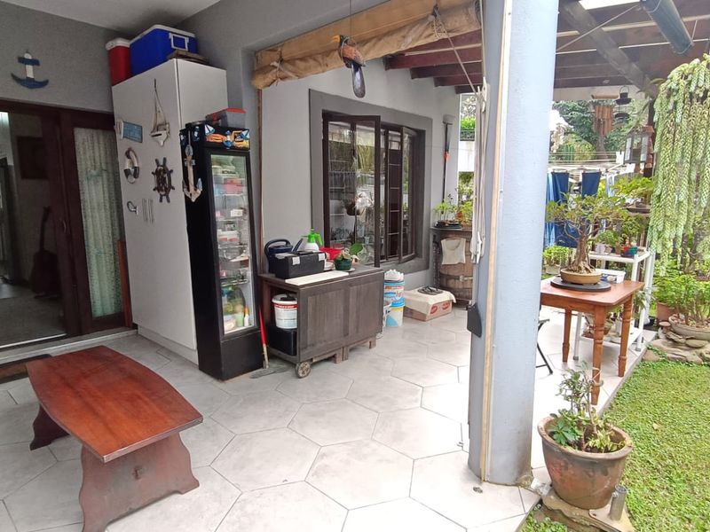 A covered patio area featuring tiled flooring and a sliding glass door providing access to the interior living space.