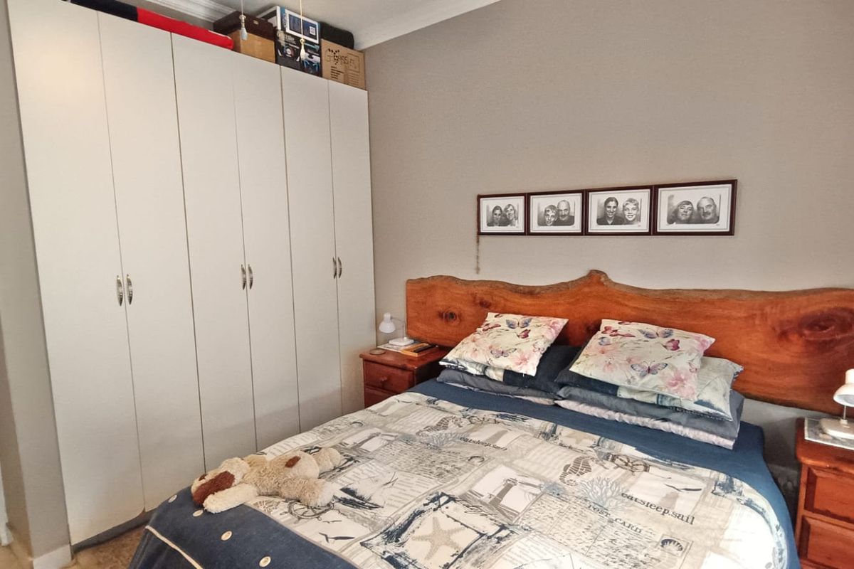 A bedroom featuring built-in cupboards with white doors and crown molding, providing functional storage space.