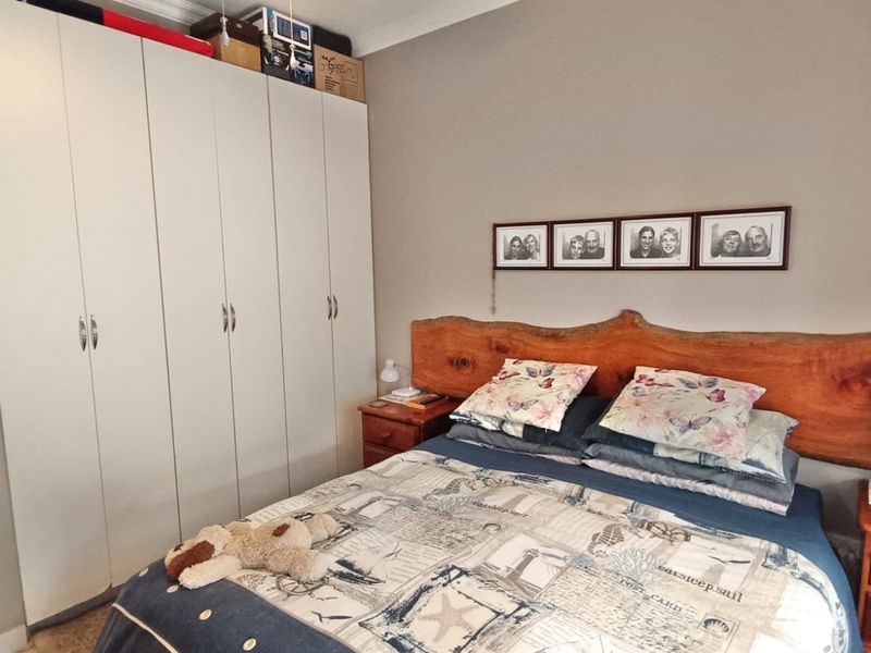 A bedroom featuring built-in cupboards with white doors and crown molding, providing functional storage space.