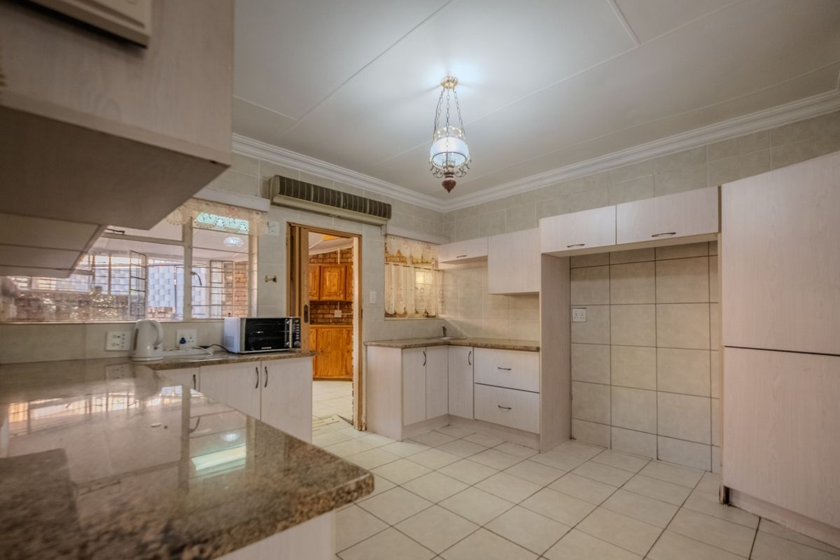 A functional kitchen featuring granite countertops, tiled backsplash, and ample built-in cabinetry, offering a clean canvas for modern updates.