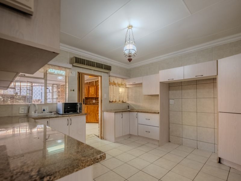 A functional kitchen featuring granite countertops, tiled backsplash, and ample built-in cabinetry, offering a clean canvas for modern updates.