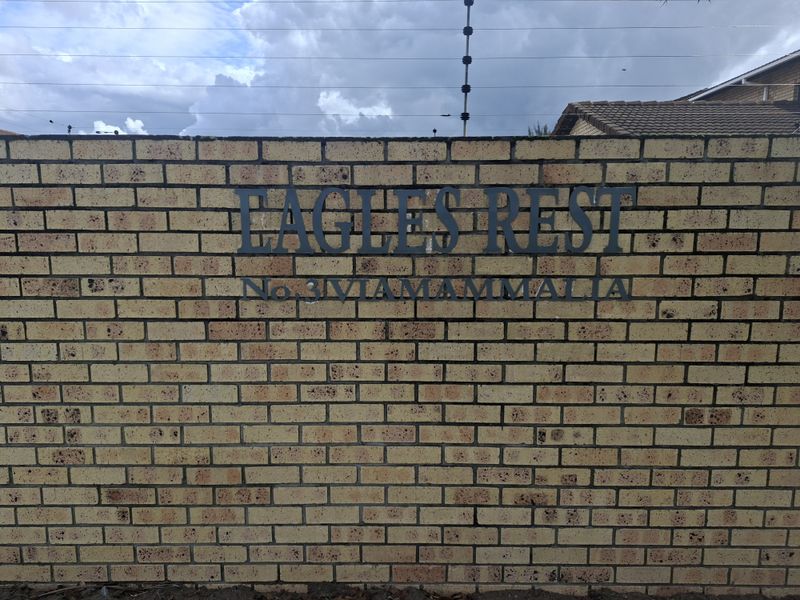 A view of the brick boundary wall and electric fencing at the entrance of the Eagles Rest townhouse complex.