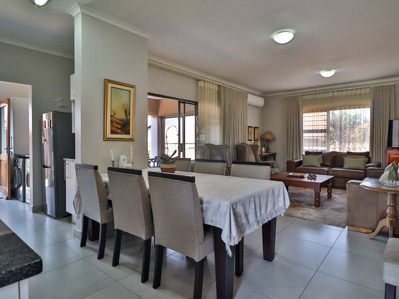 Spacious open-plan living and dining area featuring tiled flooring, neutral walls, and direct access to an outdoor patio through sliding glass doors.