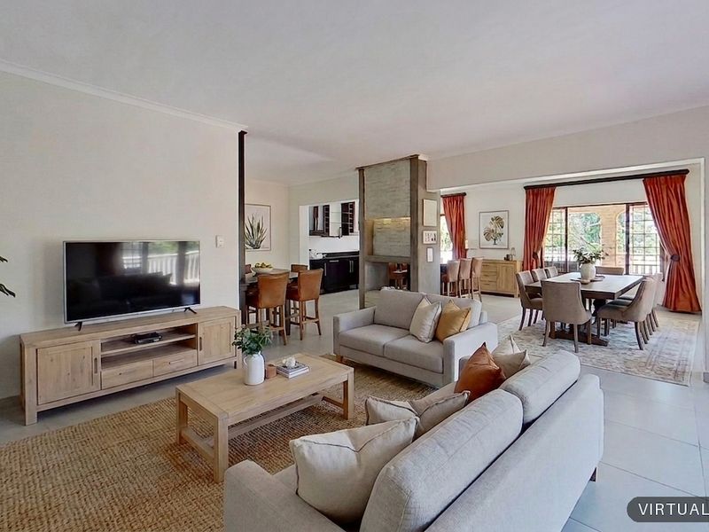 Spacious open-plan living and dining area featuring tiled floors, a central built-in fireplace, and large sliding doors leading to the outdoor space.