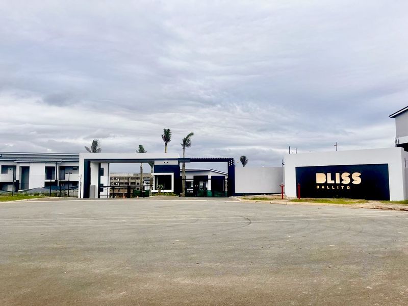 The main entrance and security gatehouse of the Bliss Ballito apartment complex, featuring modern architectural design and clear signage.