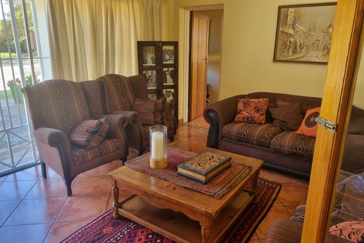 A comfortable living room featuring terracotta floor tiles and a sliding glass door providing access to the exterior.