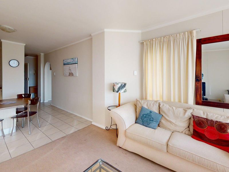 Open-plan living and dining area featuring tiled kitchen flooring, carpeted lounge space, and neutral wall finishes.