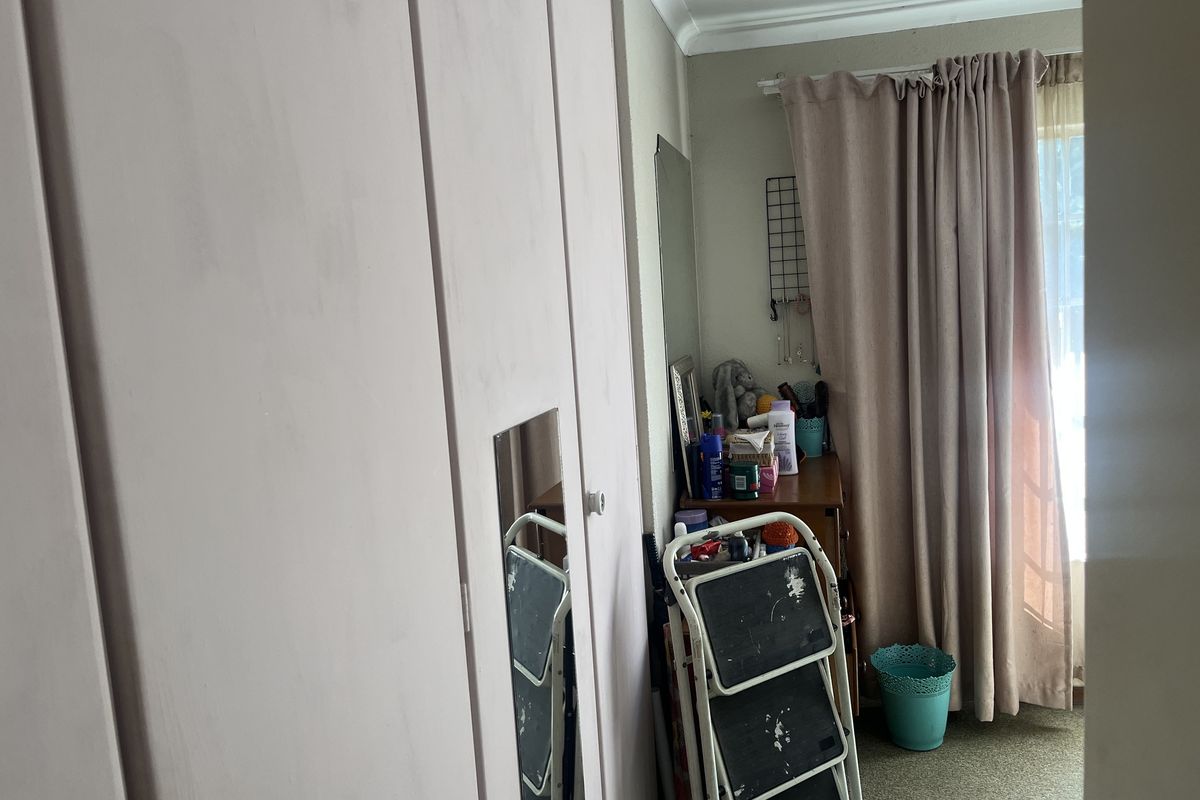 A bedroom featuring built-in wardrobes with a painted finish, coving, and carpet flooring, offering potential for cosmetic updates.