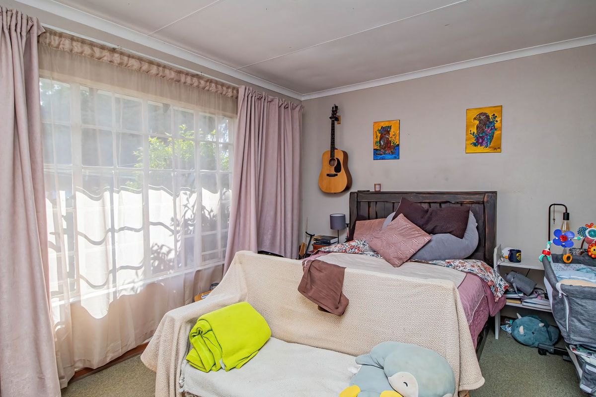 A bedroom featuring a large window with natural light and coved ceiling details, providing a comfortable space for rest.