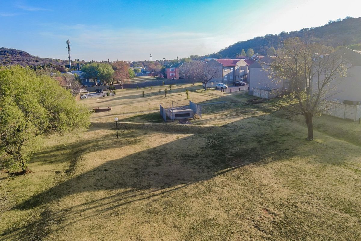 An aerial view of the apartment complex grounds, featuring open green spaces and surrounding residential buildings.