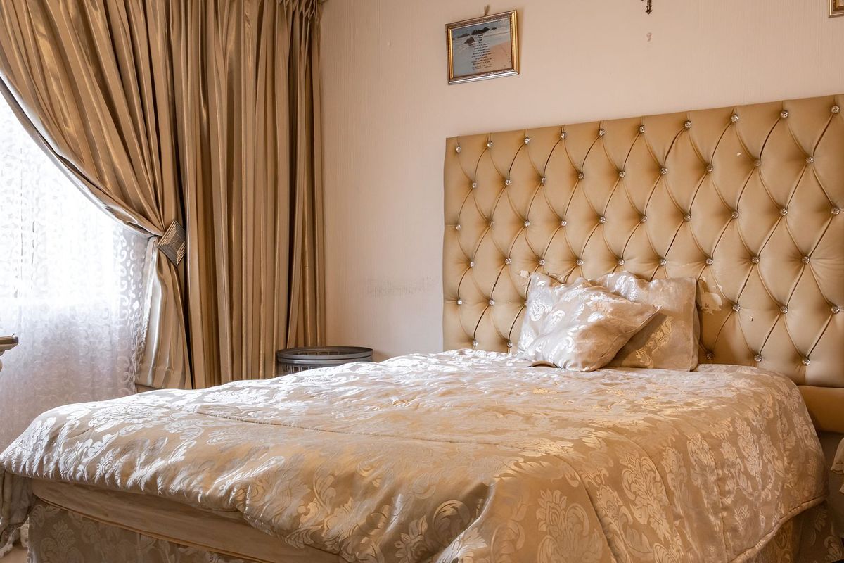 A bedroom featuring neutral wall finishes and window treatments, providing a comfortable and functional sleeping space.