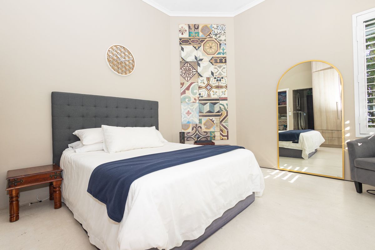 A well-maintained bedroom featuring neutral walls, built-in wardrobe storage, and plantation shutters, offering a clean and comfortable living space.