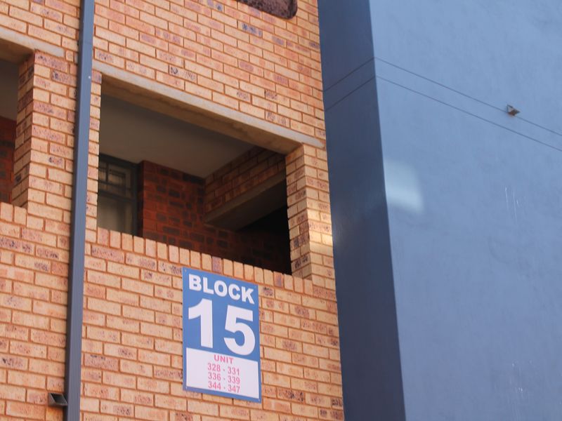 Exterior view of apartment block 15, featuring face brick construction and painted structural elements with clear unit identification signage.