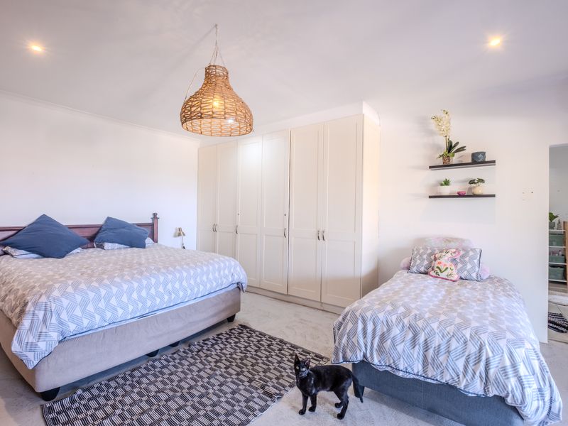 Spacious bedroom featuring extensive built-in cabinetry, recessed lighting, and a wall-mounted air conditioning unit, providing ample storage and climate control.