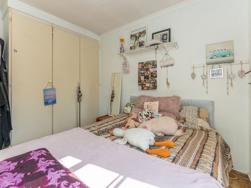 A bedroom featuring built-in cupboards and neutral wall finishes, offering a functional space ready for personalization.
