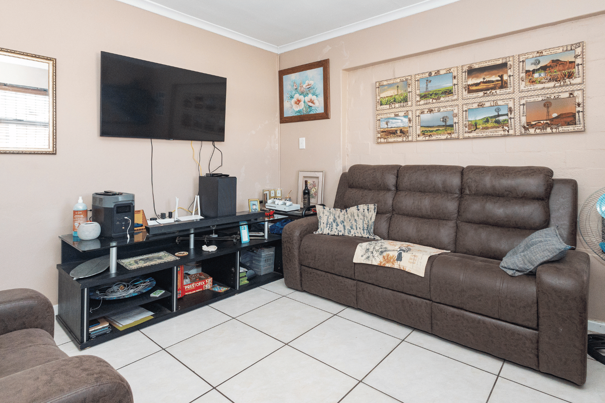 A living room featuring tiled flooring and neutral wall finishes, providing a functional space for relaxation.