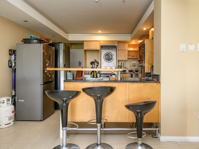 A functional kitchen featuring light wood cabinetry, granite countertops, a breakfast bar, and integrated appliances, offering a practical layout for daily use.