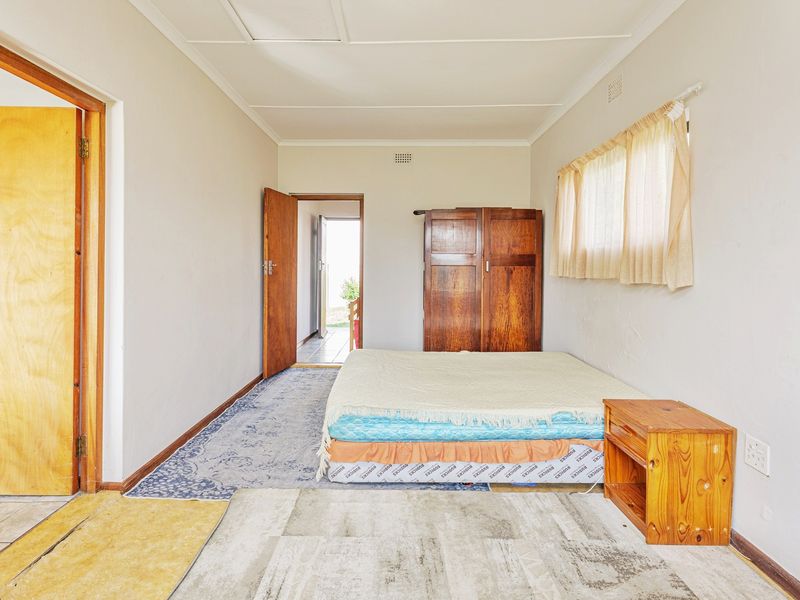 A bedroom featuring neutral walls, timber door frames, and a ceiling vent, requiring cosmetic updates to improve its overall condition and appeal.