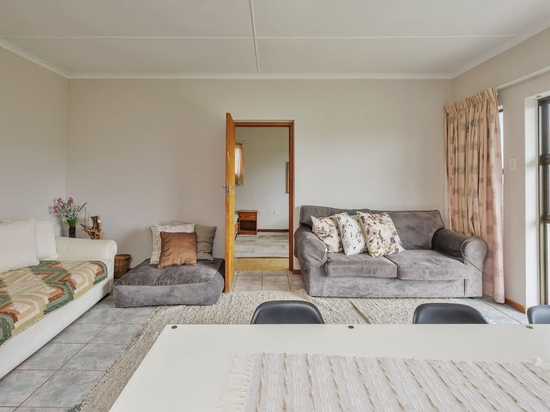 A functional living area featuring tiled flooring and a large aluminium sliding door providing natural light and garden access.